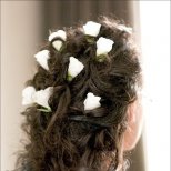 Сватбена прическа за дълга коса с бели деликатни цветя