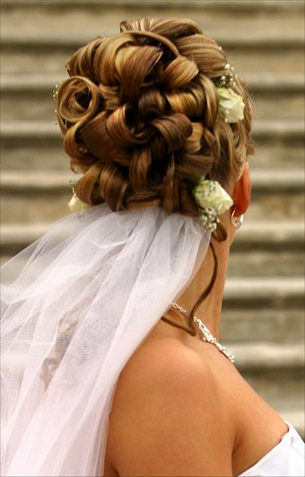 красиво преплетена коса на булка с красиви цветя