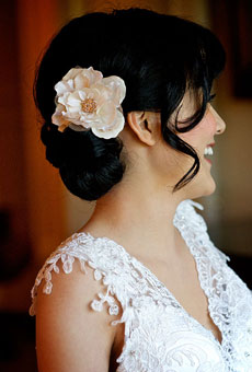 Латино прическа с ниско завита коса, украсена с копринено цвете