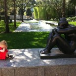 детенце позира със статуя