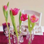 Декорация за маса с лилава покривка и лалета в стъклени вазички