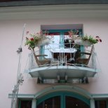 Малък балкон с 2 стола и цветя