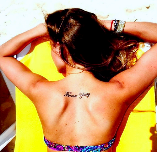 Татуировка надпис Forever Young на гърба между плешките