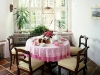Малка трапезария с кръгла маса и дръвени столове, розова покривка