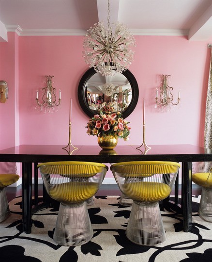 Интериор трапезария с розови стени, черна маса и жълти столове с кристални лампи