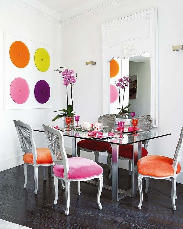 Интериор за трапезария с маса стъкло и разноцветни столове
