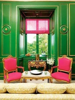 Интериор с неокласически стил с ярко зелени стени, розови столове и малка светла масичка за чай