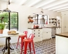 Бяла кухня с дървен плот и червени столчета