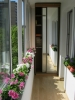 Остъклен балкон с цветя и гардероб