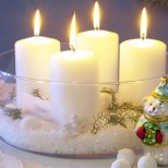 Коледна украса с изкуствен сняг и свещи в купа