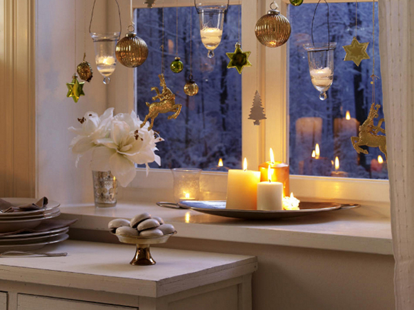 Красива коледна декорация със свещи край прозореца